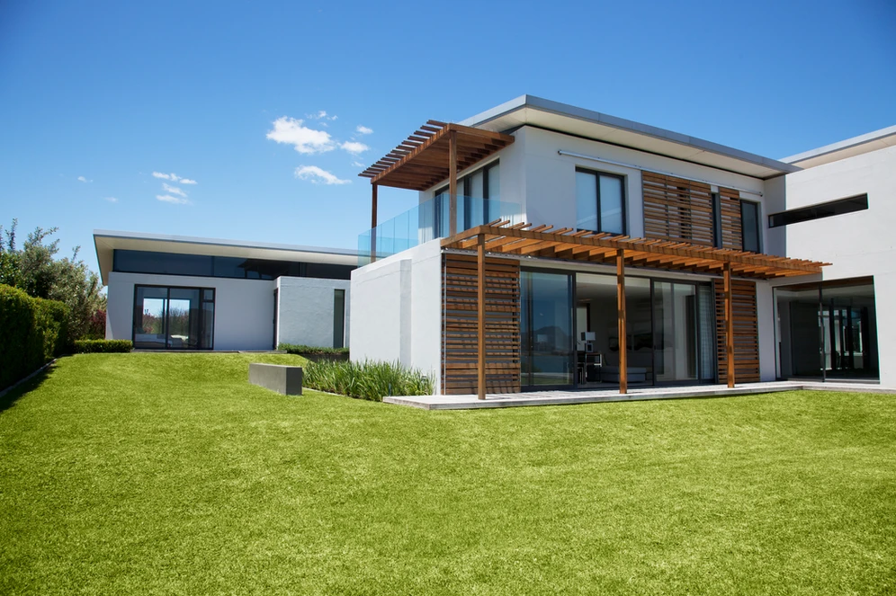 A contemporary house with a lush green lawn and a wooden deck, blending modern design with natural elements. A contemporary house with a lush green lawn and a wooden deck, blending modern design with natural elements.